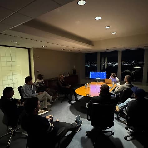 The team watching a screen in a dim conference room