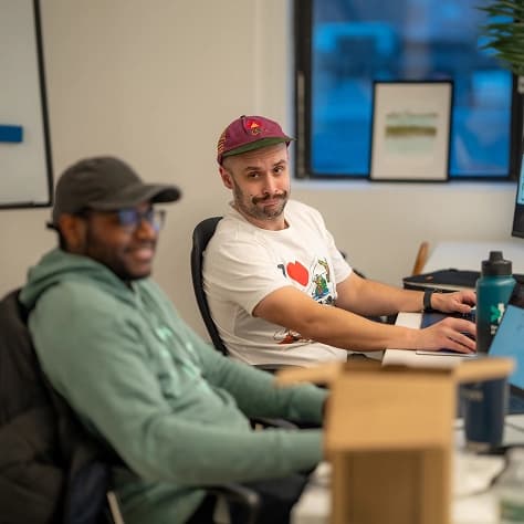 Two teammates at their desks